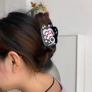 Detail view of cartoon bear paw hair claw clip styled on back of head hair bun