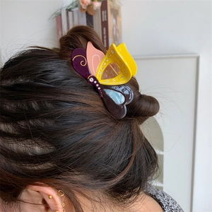 Detailaufnahme einer bunten Schmetterlings-Haarklammer aus Acetat mit Glitzersteinen