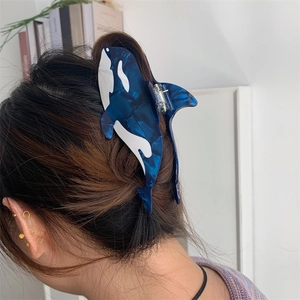 Orca-shaped acetate hair claw clip with dark blue marble pattern for women's hairstyle