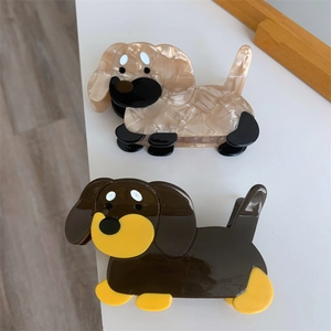 Detail view of cartoon dachshund acetate claw clips in marble beige and solid brown
