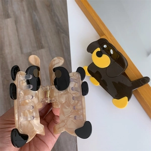 Detail showing cartoon dog hair claw clips with marble texture and sturdy inner metal spring