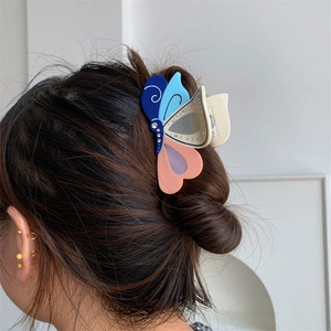 Detailansicht der bunten Schmetterlings-Haarklammer aus Acetat am Haarknoten