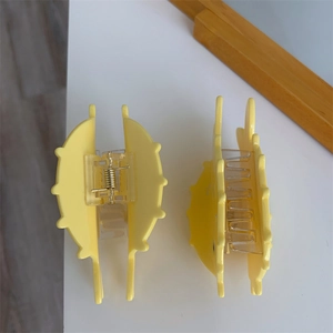 Detail of two cute yellow sunflower-shaped hair claws made of high-quality acrylic