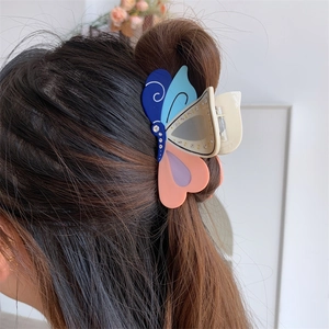 Modell trägt eine bunte Schmetterling Haarklammer mit Strasssteinen im Haar