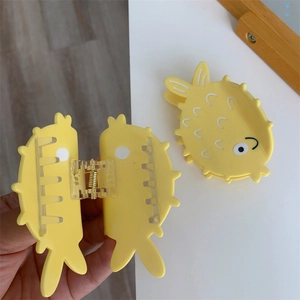 Detail of yellow puffer fish hair claw clips with secure metal spring and textured finish
