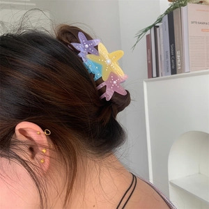 Detail of starfish hair claw clip with pearls and rhinestones on hair for women