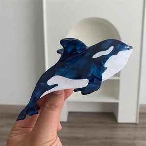 Detail view of orca shaped hair claw clip made of premium marble texture acetate material