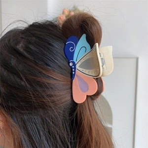 Detail einer bunten Schmetterlings-Haarklammer mit Strasssteinen beim Styling