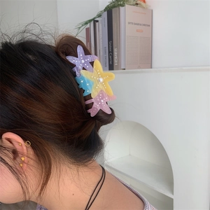 Macaron starfish hair claw clips with pearls and crystals shown on hair bun