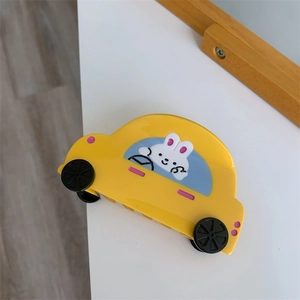 Close-up of a yellow car-shaped hair claw clip with a cute bunny driver design