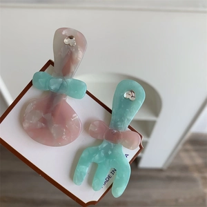 Dettaglio di fermagli per capelli a forma di cucchiaio e forchetta con fiocco e strass
