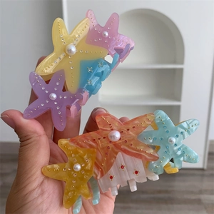 Close-up of starfish hair clips with pastel colors and inlaid pearls and rhinestones