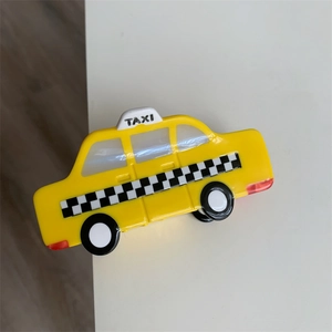 Detail view of yellow acetate taxi hair claw clip with checkered pattern and TAXI logo
