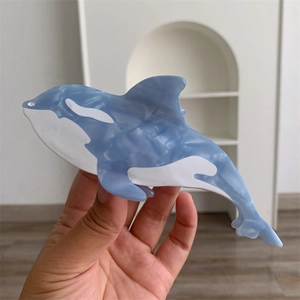 Detailed close-up of a large orca whale acetate hair claw clip with marble texture