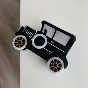 Close-up of vintage car claw clip showing white marble acetate and golden details