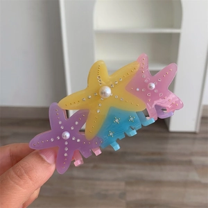Detail of colorful starfish hair claw clip with rhinestones and white pearls decoration