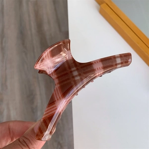Detailed view of large checkered hair claw clip in brown and beige resin material