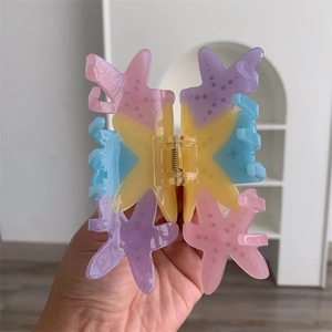 Detailed close-up of a colorful starfish-shaped hair claw clip with macaron resin textures