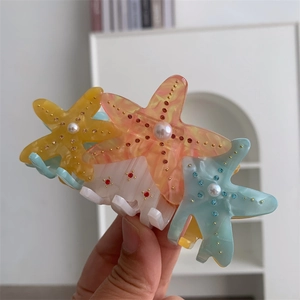 Macro detail of starfish hair claw clip with colorful resin, pearls and crystals