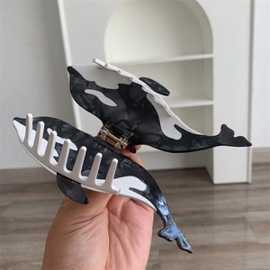 Detailed view of orca whale acetate hair claw clip with black and white marble pattern