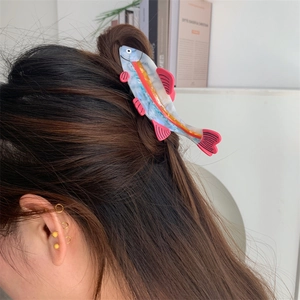 Pink fish-shaped hair claw clip made of acetate for half-tied hairstyles on a woman