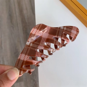 Detail view of large red plaid claw clip with interlocking teeth for a secure grip