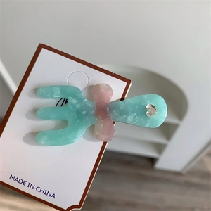 Dettaglio della clip per capelli creativa in acetato con fiocco e strass lucido