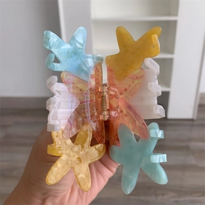 Detail of colorful starfish hair claw clip featuring blue and yellow marble texture