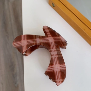 Detail showing high-gloss brown and pink plaid pattern on large hair claw clip