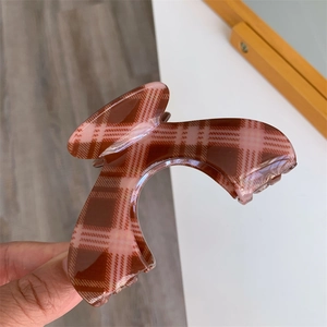 Detailed view of large red and brown plaid claw clip with strong metal spring