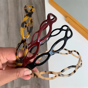 Close-up of four hollow resin headbands in tortoiseshell, burgundy, black and marble finish