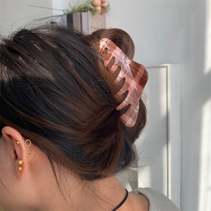Classic red plaid pattern hair claw clip for women shown on a model in a natural setting