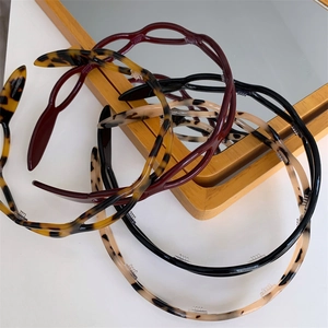 Detail of multi-colored acetate headbands with wave hollow design and non-slip inner teeth
