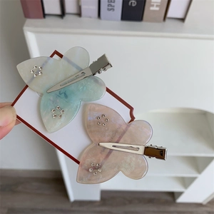 Dettaglio di fermagli per capelli a farfalla rosa e blu con strass e clip in metallo
