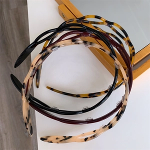 Close-up of wavy acetate headbands with tortoiseshell pattern and non-slip inner teeth