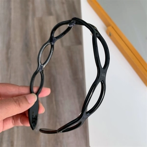 Detail of black glossy headband featuring an elegant hollow oval chain link design
