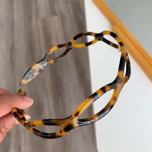 Detail of tortoise shell patterned acetate headband with unique hollow wave design
