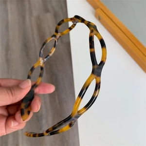 Detailed shot of acetate hair hoop featuring leopard print hollow chain link structure