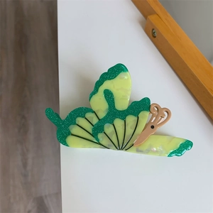 Detail of green and yellow butterfly hair claw clip with pearlescent texture finish