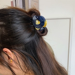 Pince à cheveux baleine en acétate avec motif marbré bleu et jaune sur un modèle