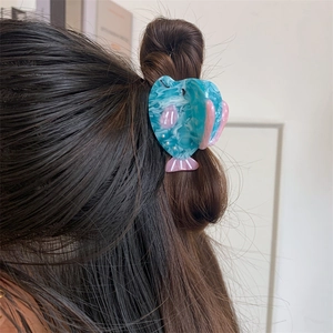Pince à cheveux baleine bleue marbrée avec nageoires roses sur cheveux bruns