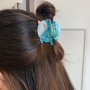 Détail macro d'une pince à cheveux baleine en acétate bleu marbré et perles