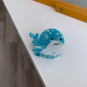 Vue détaillée d'une pince à cheveux baleine bleue mignonne avec texture acétate et perles