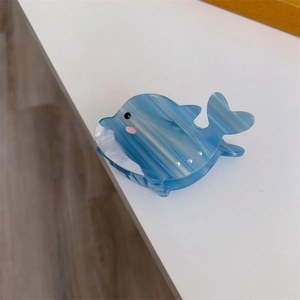 Détail de la pince à cheveux baleine en acétate marbré bleu avec perles et design doux