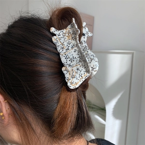 Detail showing high-quality acetate leopard print hair claw clip on model's hair