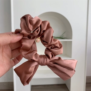 Luxurious brown satin bow scrunchie made of silky fabric for elegant hairstyles