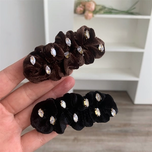 Détail de barrettes en velours avec cristaux marquise en noir et marron foncé