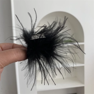 Détail d'une pince à cheveux élégante en plumes noires avec base en métal argenté