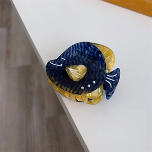 Gros plan sur la pince a cheveux baleine en acetate avec perles et motif marbre
