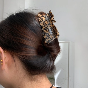 Detail view of a leopard print cat claw clip worn on hair for a trendy aesthetic look